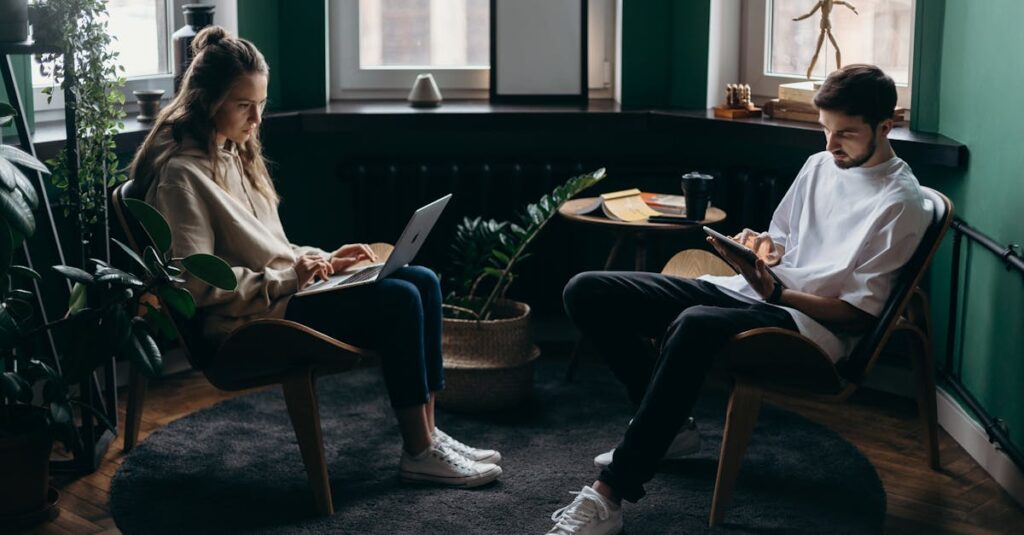 Two remote workers collaborating in a cozy home office with laptops and plants, creating a modern workspace atmosphere.